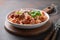 Pasta fettuccine with meatballs, parmesan, tomatoes, basil on brown. Close up.