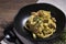 Pasta fettucine with mushrooms and creamy pesto sauce on rustic wooden background