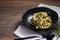 Pasta fettucine with mushrooms and creamy pesto sauce on rustic wooden background