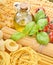 Pasta with fresh tomatoes, basil and olive oil on light shabby rustic background, top view, border. Pasta with