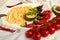 Pasta with fried eggplants, tomatoes and green avocado decorated with cherry tomatoes, chili peppers and fork