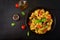 Pasta Fusilli with tomatoes, beef and basil in black bowl on table