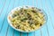 Pasta with grilled turkey, pesto sauce and fennel in serving plate over wooden turquoise background