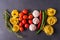 Pasta and Ingredients for cooking on dark background, top view. Pasta, tomatoes, garlic, rosemary, peppers