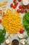 Pasta and Italian food ingredients for cooking lunch, top view. Fusilli spaghetti with various ingredients - tomatoes, rosemary,