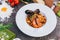 Pasta with king prawns on a gray background in a white dish.