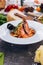 Pasta with king prawns on a gray background in a white dish.