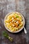 Pasta Mafaldine Napoletane with baked pumpkin, feta cheese and seasoning herbs in ceramic plate on gray concrete old background.