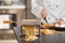 Pasta maker with dough and blurred chef on background