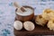 Pasta nests, eggs and bowl of flour on wooden board