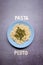 Pasta Pesto with green sauce served on a blue plate on a grey background with pasta and pesto written on wooden letters