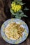 Pasta rigata with organic romanesco broccoli sauce on black wooden background