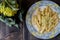 Pasta rigata with organic romanesco broccoli sauce on black wooden background