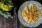 Pasta rigata with organic romanesco broccoli sauce and sprinkled with toasted breadcrumbs on black wooden background