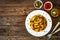 Pasta with roasted pork meat - noodles witch pork cheeks and vegetables on wooden background