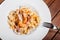 Pasta with seafood, shrimp, mussels, octopus, oysters, herbs and cream sauce on wooden background