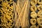 Pasta shapes, spaghetti, fusilli, tagliatelle, Italian cuisine ingredients on a wooden background