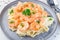 Pasta with shrimps in creamy parmesan cheese and garlic sauce garnished with parsley, fettucini alfredo, horizontal,  closeup