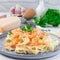 Pasta with shrimps in creamy parmesan cheese and garlic sauce garnished with parsley, fettucini alfredo, square format