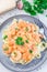 Pasta with shrimps in creamy parmesan cheese and garlic sauce garnished with parsley, fettucini alfredo, vertical, top view,