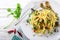 Pasta, spaghetti with artichokes, chili pepper, garlic, olive oil and parsley on white wooden background, top view.