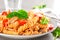 Pasta spirali stirred with fried pieces of chicken, cherry tomatoes