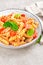 Pasta spirali stirred with fried pieces of chicken, cherry tomatoes