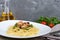 Pasta tagliatelle with seafood and cream sauce on a white plate on a wooden table