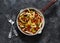 Pasta, zucchini, mushrooms, sweet paprika vegetable stewed tomato sauce in a pan on a dark background, top view. Vegetarian food