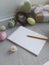 Paste  Easter holiday eggs,  giftbox and blank notebook with pencil on grey background.