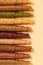 Paste. Pattern of various pastila fruit leather rolls with fruit on a beige background. Vertical.