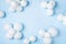 Pastel blue table with white balloons and confetti top view. Party or birthday background. Flat lay style