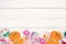 Pastel Christmas sweets decor, bottom border over white wood