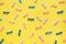 Pastel colored baby confetti on yellow background