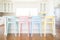 pastel-colored counter chairs lined up in a bright, modern kitchen