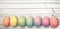 Pastel colored eggs on white wooden planks, panoramic easter background