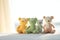 Pastel-colored orange and green teddy bears seated against a sunny window create an image of gentle warmth and