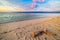 Pastel colored sky, clouds and seascape at dusk. Wide angle view from sandy beach with trunk fragment in the foreground. Tanjung K