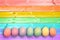Pastel colorful rainbow painted eggs wood planks background