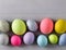 Pastel coloured Easter eggs over grey