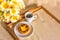 Pastel de nata cake, a cup of Portuguese black coffee and a bouquet of daisies on a tray. Top view