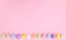 Pastel Easter eggs on bright pink background neatly ordered on the bottom. Spring holidays copy space concept