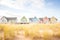 pastel multicolor row of beach cottages with dune grass