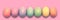 Pastel painted Easter eggs aligned in a row on pink panoramic background Easter web banner