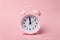 Pastel pink alarm clocks on pink backdrop. Time concept. Minimal composition. Close-Up Of Alarm Clock On Table Against Pink Wall