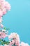 Pastel pink blooming flowers and blue sky in a dream garden, floral background