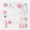 Pastel pink cosmetic product setting flat lay with flowers on white desk background, top view, frame. Layout for skin care
