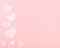 Pastel Pink Valentine Hearts on Pink Paper with space for copy, text or your words.  It`s a horizontal photo with an above view a