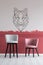 Pastel pink and velvet bar stools in empty interior with burgundy and white ombre wall