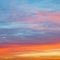 Pastel pink and yellow sunrise clouds in blue sky